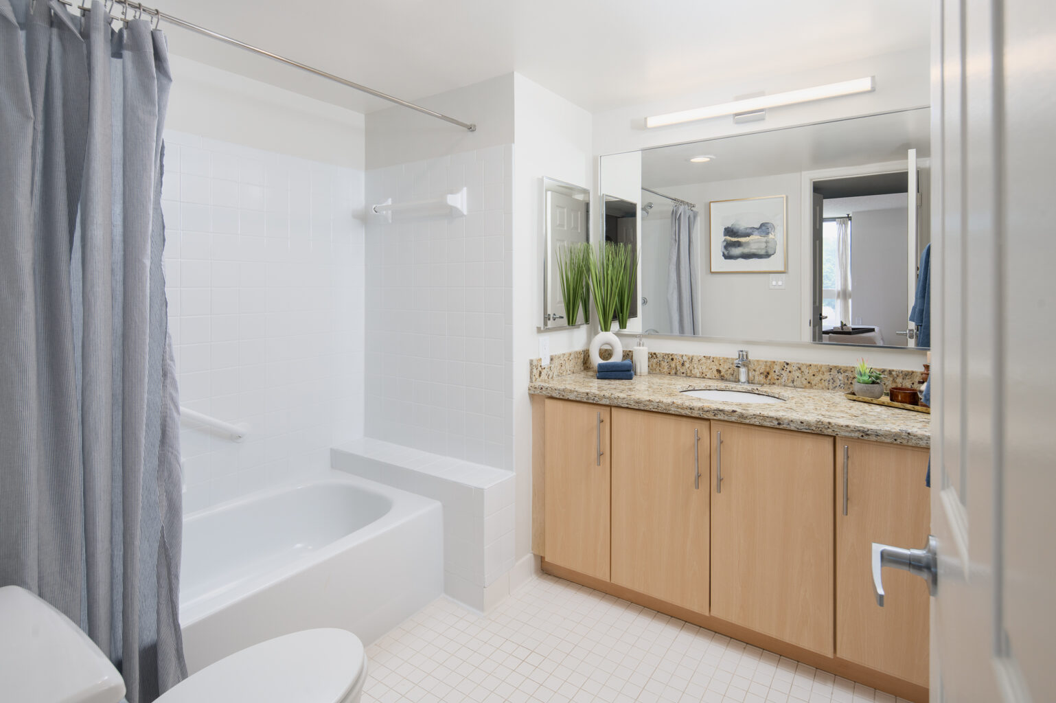 A small bathroom with modern finishes and ample mirrors.